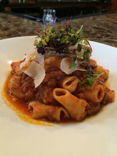 Ragu over homemade pasta with microgreens.