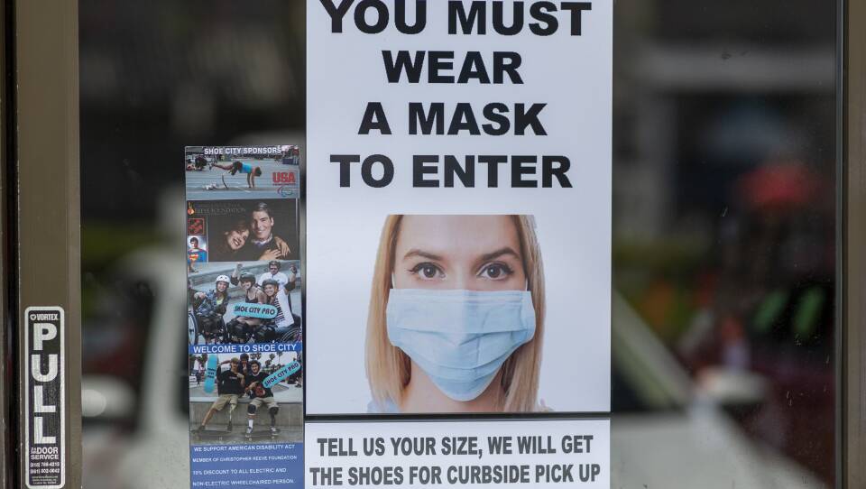 Masks are required for entry to a shoe store in Glendale, Calif. Most people follow social distancing and guidelines to wear masks when they enter retail stores and restaurants, but some customers don't comply.