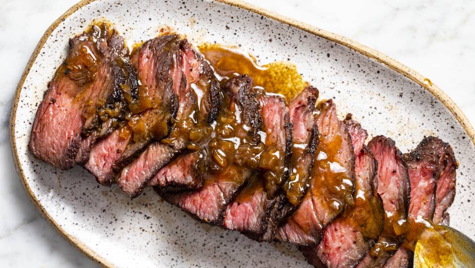 Plate topped with sliced medium-rare short ribs with a browned butter sauce