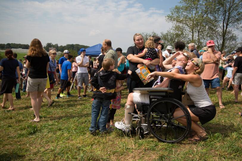  Rebecca Theriault (immediately behind wheelchair) looks up at the eclipse with her mom on UConn's Horsebarn Hill in 2017.
