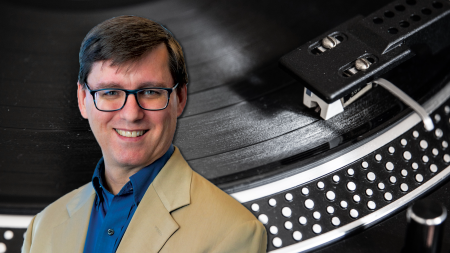 A man's face is overlaid over a record player.