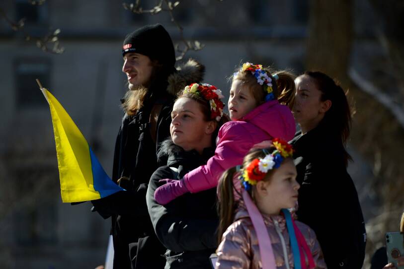 A family stands outside together looking off into the distance.