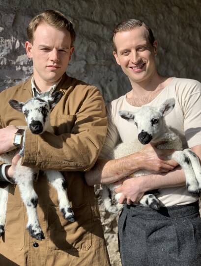 Tristan and James hold adorable lambs