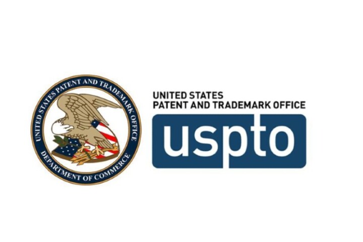 A logo featuring the seal for the United States Patent and Trademark Office, Department of Commerce, which includes a bald eagle and American flag insignia in the center of a navy circle.