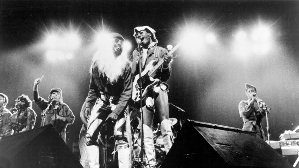 A black-and-white photograph of a funk band performing on stage.