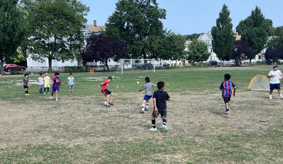 Boys play soccer on an outdoor field.