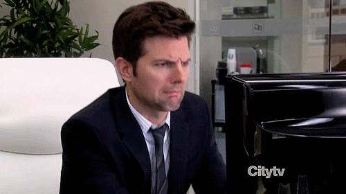 Adam Scott, as Ben in Parks and Rec, makes a grossed out face and leaps back from his computer.