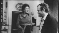 A man in a buttondown is smiling with Julia Child on set