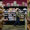 A man reaches for what looks like yogurt in a well-stocked grocery store.