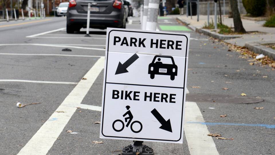 A sign directs cars to one side of a divider, and cyclists to the other.