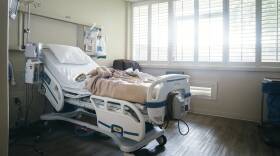 Empty hospital bed near sunny window