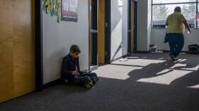 A young child plays alone on his iPad.