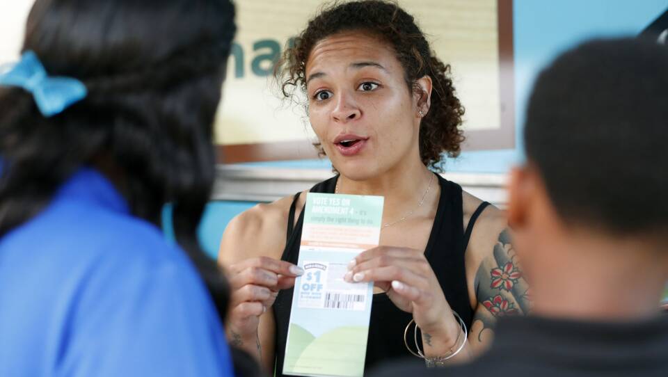 Jessica Jones (center) speaks to people gathered around the Ben & Jerry's "Yes on 4" Truck about Florida's Amendment 4 initiative at Charles Hadley Park in Miami, on Oct. 22. Amendment 4 asked voters to restore the voting rights of people with past felony convictions.