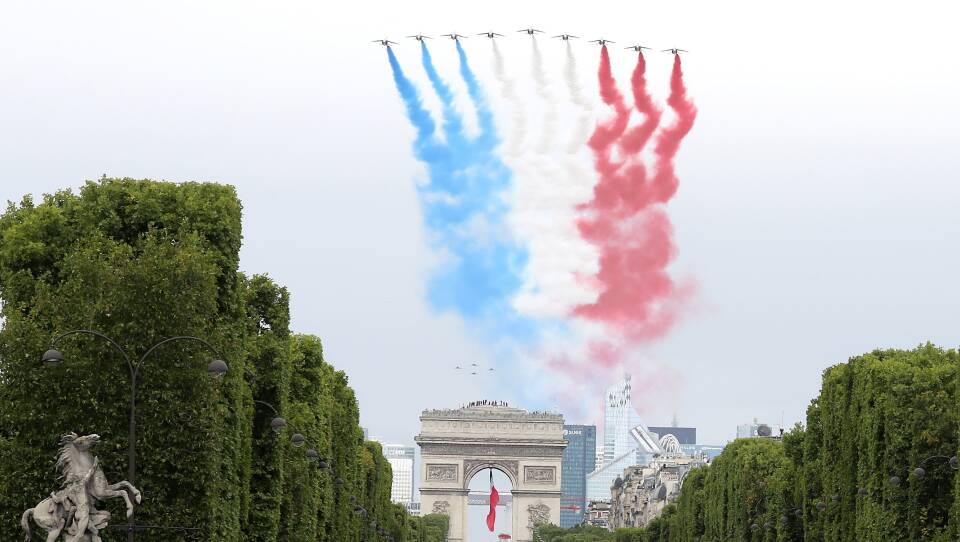 The French elite acrobatic flying team "Patrouille de France" (PAF) performs a flying display of the French national flag over the Arc de Triomphe during the annual Bastille Day military ceremony in Paris, on Tuesday.