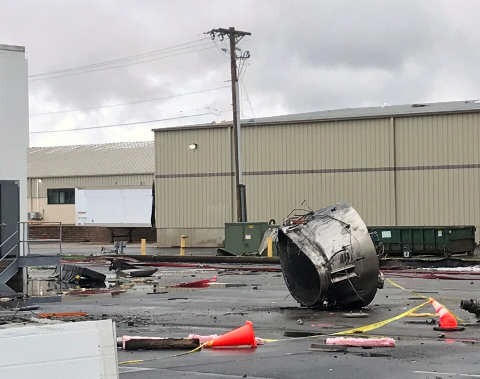 Rubble is strewn across a parking lot outside of the factory.