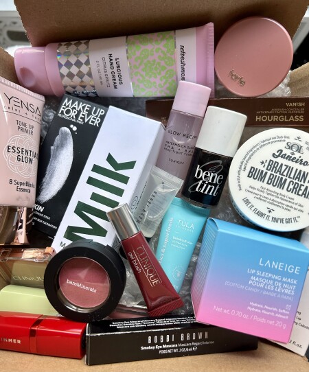 A collection of various beauty products in a cardboard box.