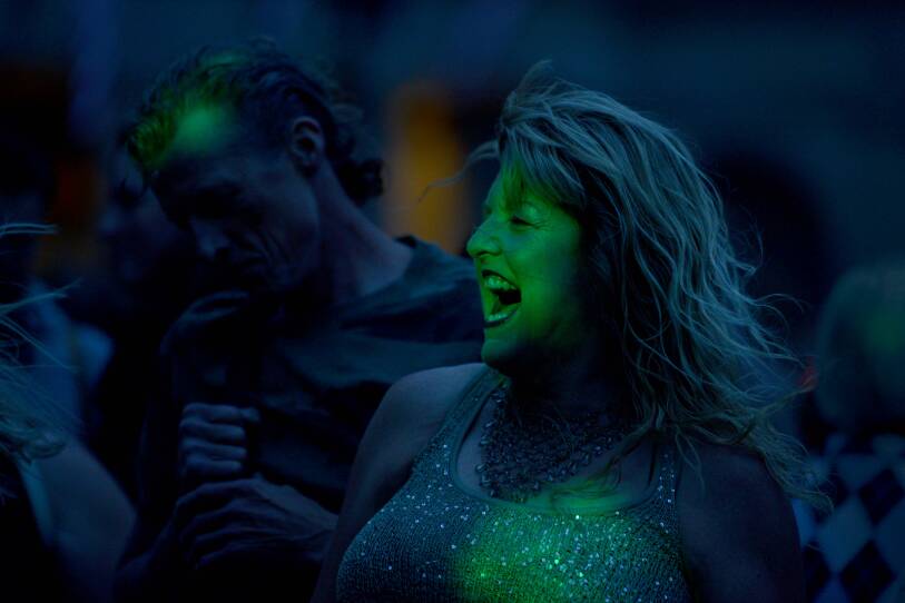 A woman smiling as she dances.