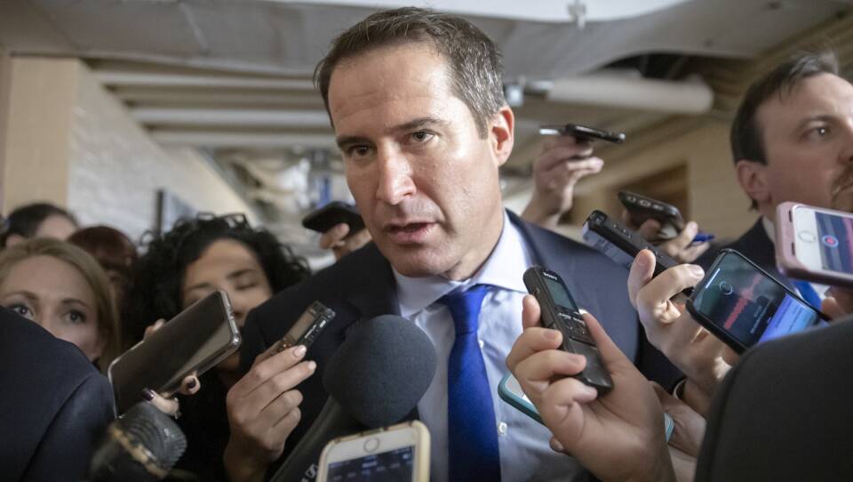 Seth Moulton standing in front of a crowd of reporters.