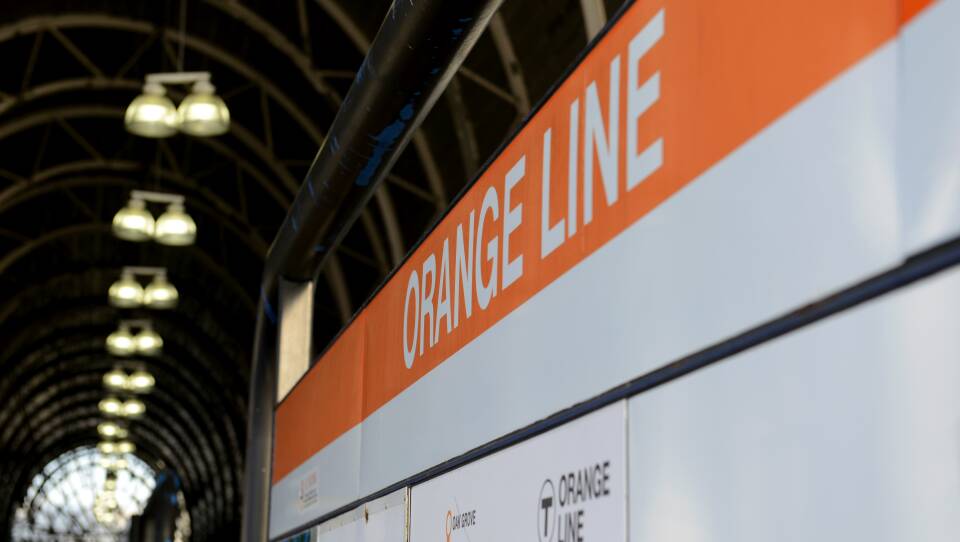 An Orange Line sign in an underground station.