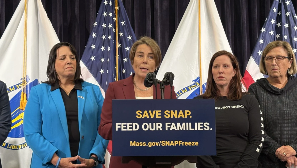 The governor speaks during a press conference over a podium that reads "Save SNAP. Feed our families." And the URL "Mass.gov/SNAPFreeze."
