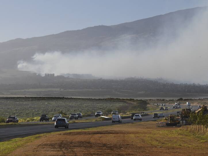 Smoke blows across the slope of Haleakala volcano on Maui, Hawaii, as a fire burns in Maui's upcountry region on Tuesday.