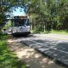 A white bus on the side of a road.