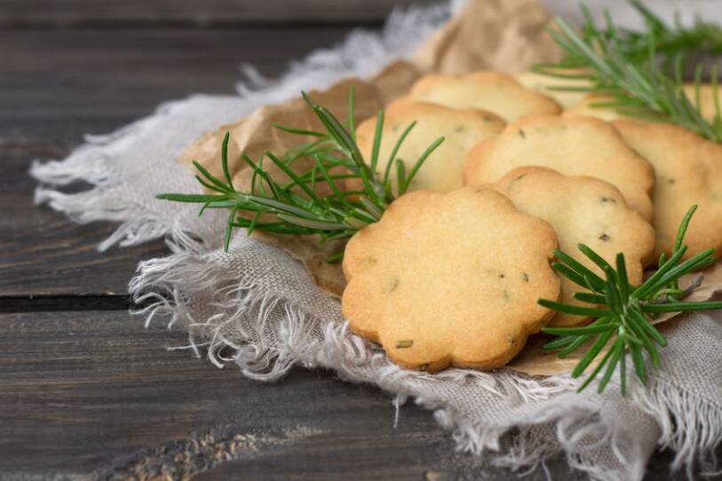Homemade cookies with rosemary on a wooden surface