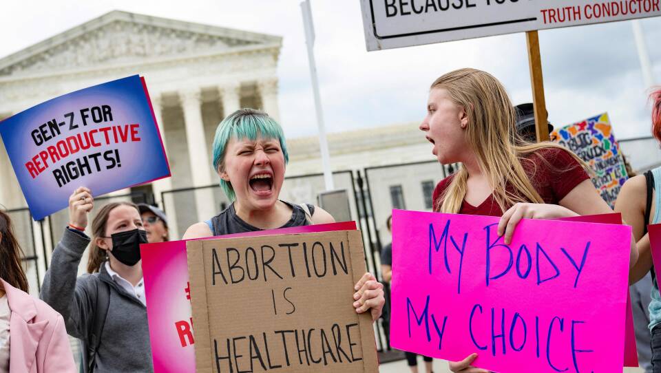 Young people who support access to abortion chant in front of un-scalable fence that stands around the US Supreme Court in Washington, DC, on May 5, 2022.