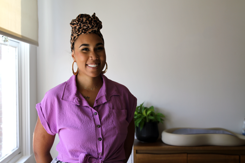 A woman in a purple shirt smiles for the camera.