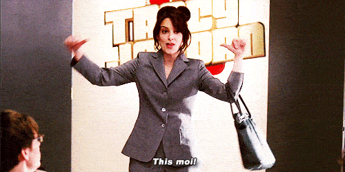 A woman points both her thumbs at herself and says "this moi!"
